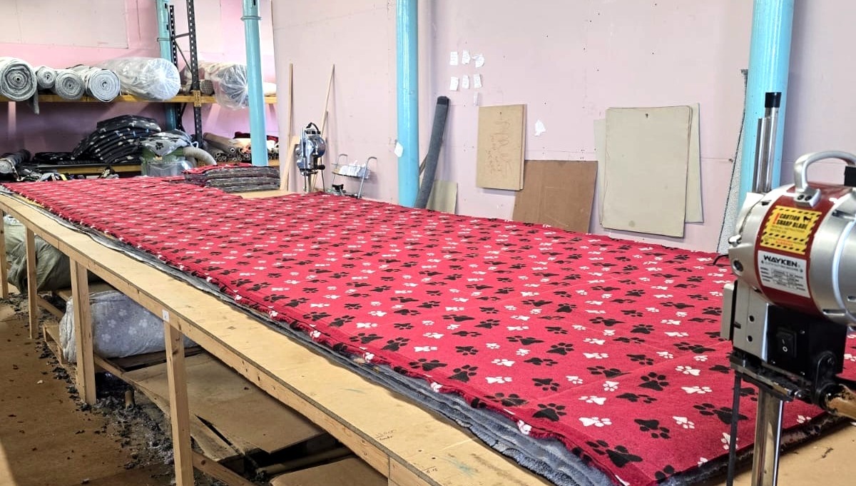 Fabric laid out on the workshop cutting table